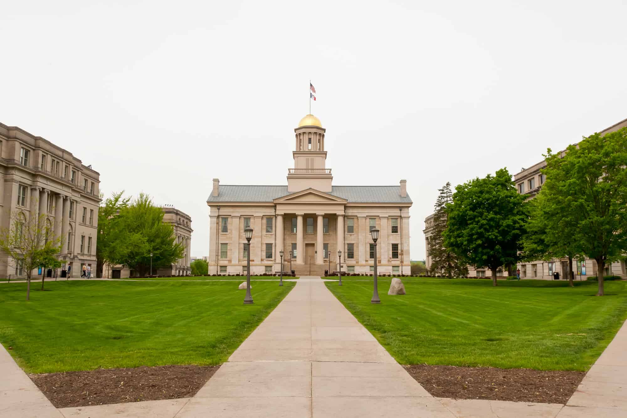 the old capital building that sits in iowa city, iowa with a gold dome and pillars out front, take time to visit the capital in between visits to the breweries in iowa city, ia