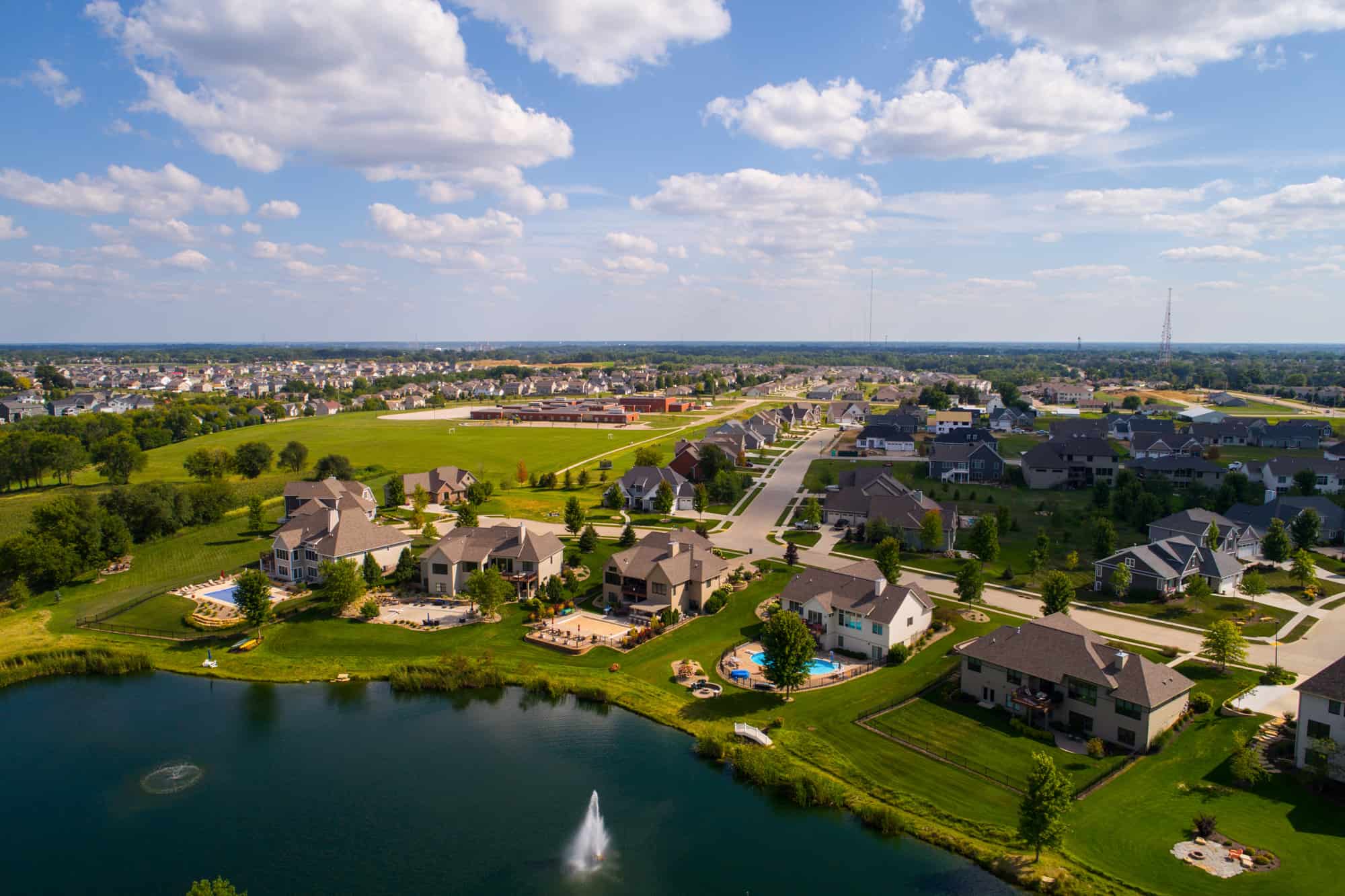suburb of the quad cities with large houses and pools next to a lake