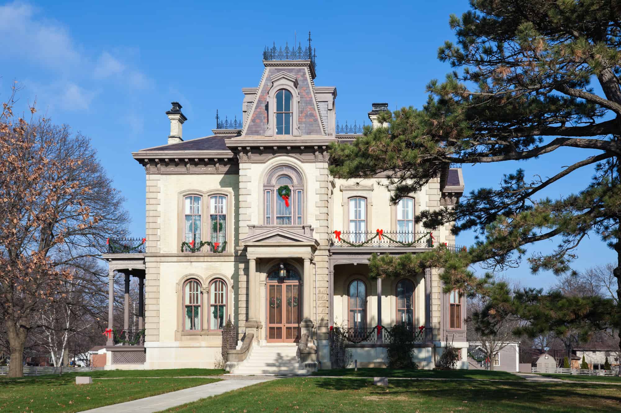 the david davis mansion in bloomington stands tall surrounded by trees and blue sky