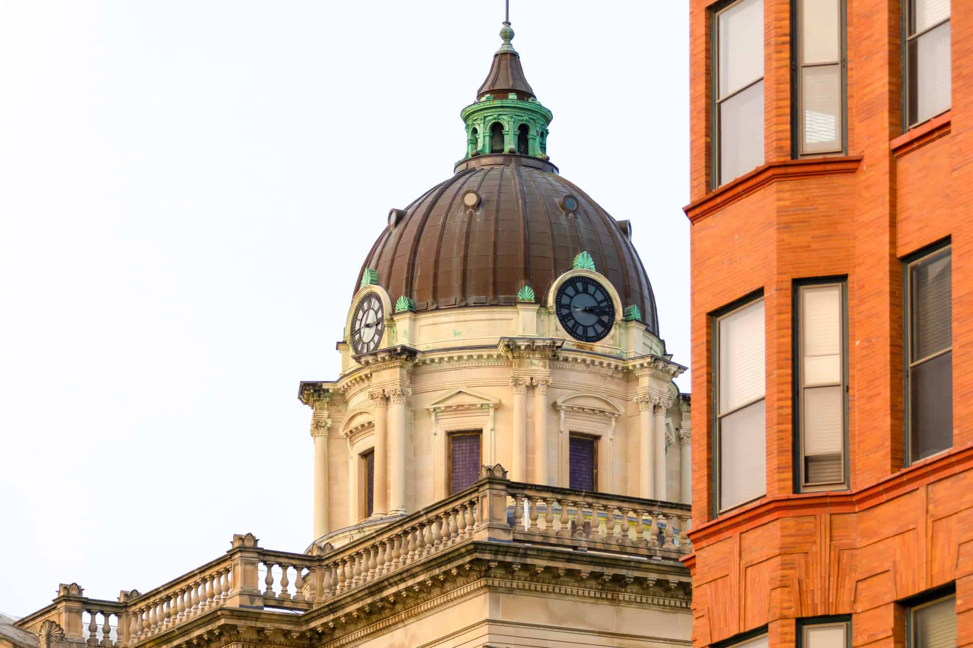 a close up of the dome on the courthouse in bloomington with a dark dome and clocks on two visible sides
