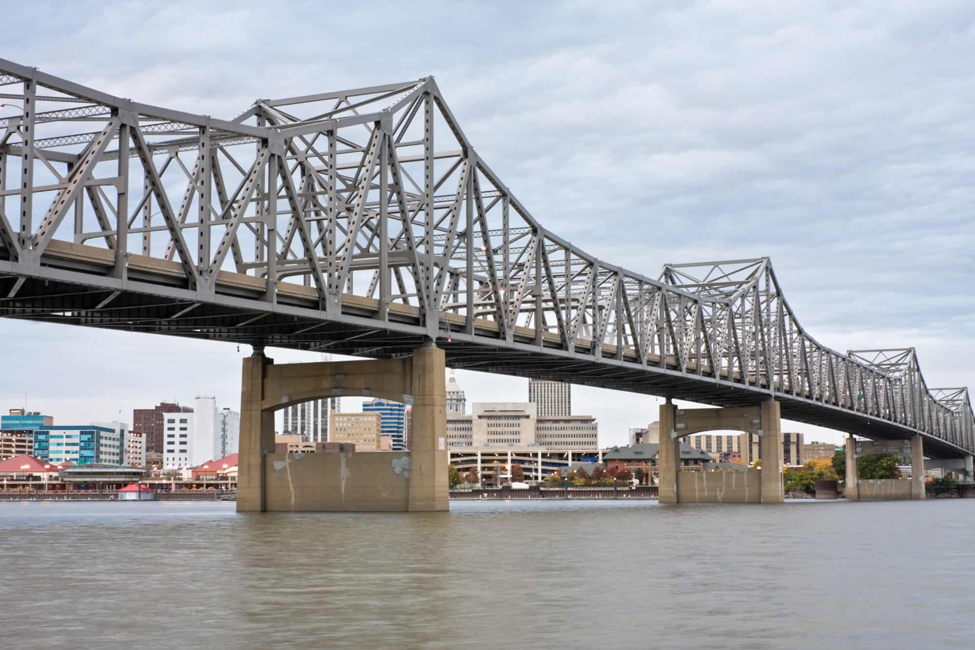 the bridge that crosses over the river along peoria is front and center in the image with downtown buildings seen behind