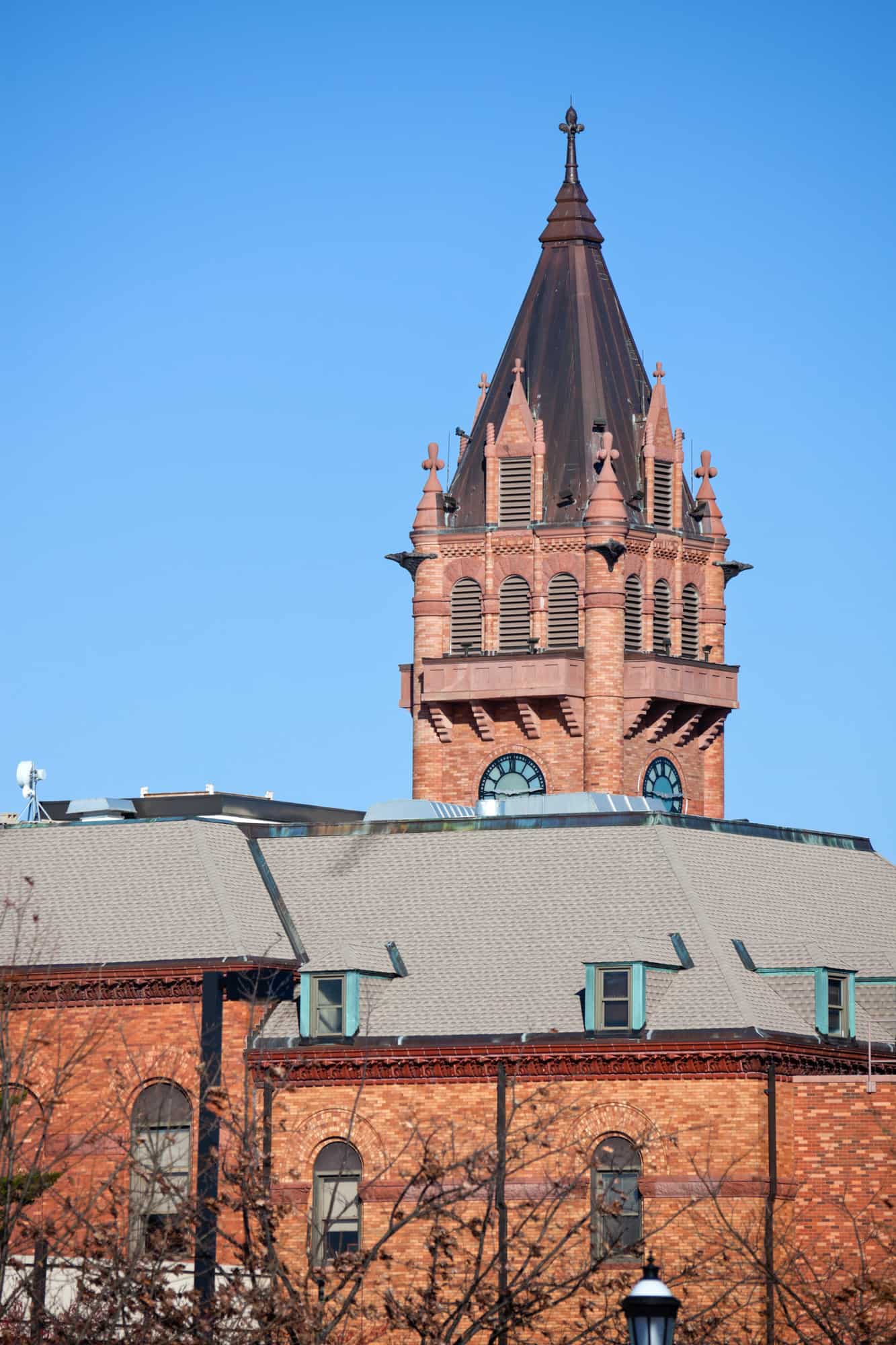 historic courthouse in urbana, a brick clock tower stands tall above the roof at the forefront of the image