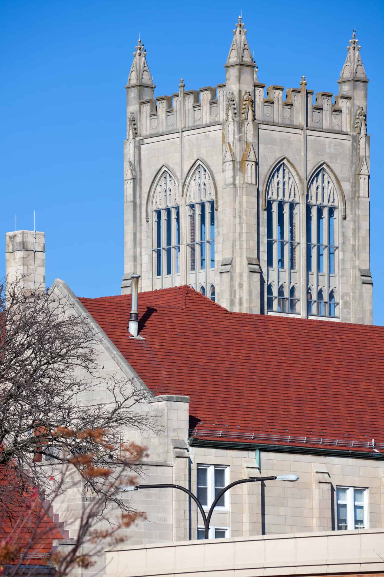 cathedral in urbana stands tall with huge glass windows seen above a red rooftop  