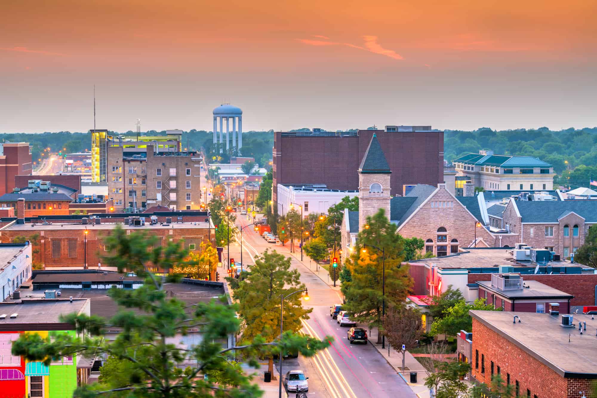 a view of Columbia from above where you can see a church, some buildings and the water tower at sunset